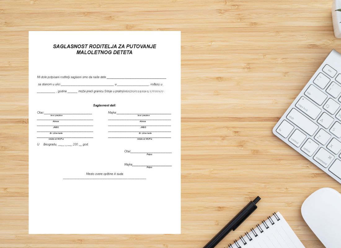 prikaz dokumenta za saglasnost za putovanje deteta na drvenom stolu na kom je hemijska, tastatura, sveska i miš