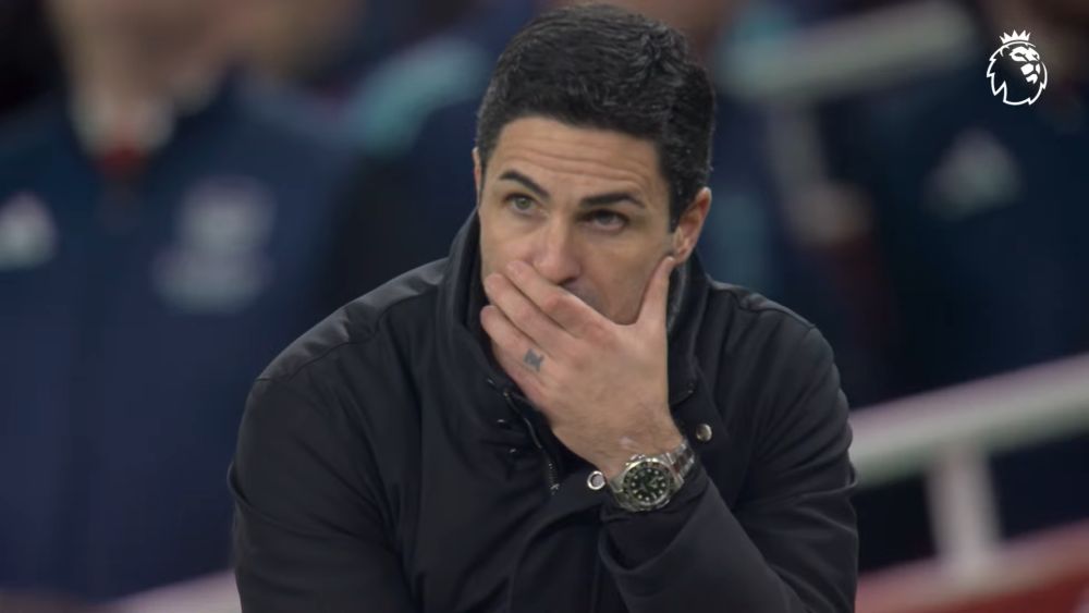 Trener Arsenala Mikel Arteta zabrinuto prati utakmicu sa klupe, sa rukom preko usta.